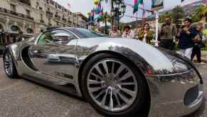 The fender of a chrome-covered Bugatti supercar parked on the streets of Monaco