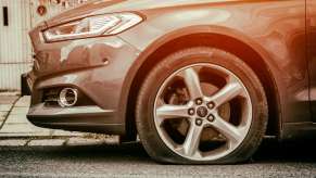 Closeup of a flat tire on a Ford fusion sedan