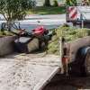 A lawn mower sits on a professional lawn service's trailer with clippings.