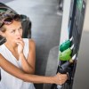 Woman chooses a fuel mix at a pump with ethanol mixes.