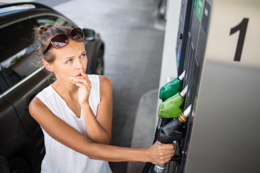 Woman chooses a fuel mix at a pump with ethanol mixes.