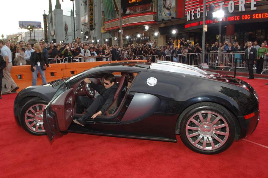 Tom Cruise tries to awkwardly get out of his Bugatti Veyron supercar