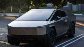 A Tesla Cybertruck parked in right front angle view in an outdoor parking lot at dusk