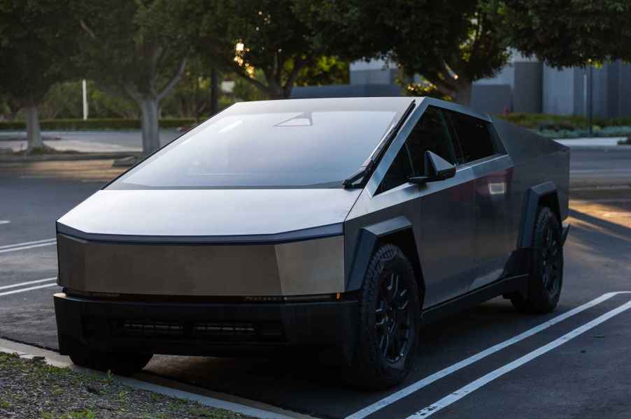 A Tesla Cybertruck parked in right front angle view in an outdoor parking lot at dusk