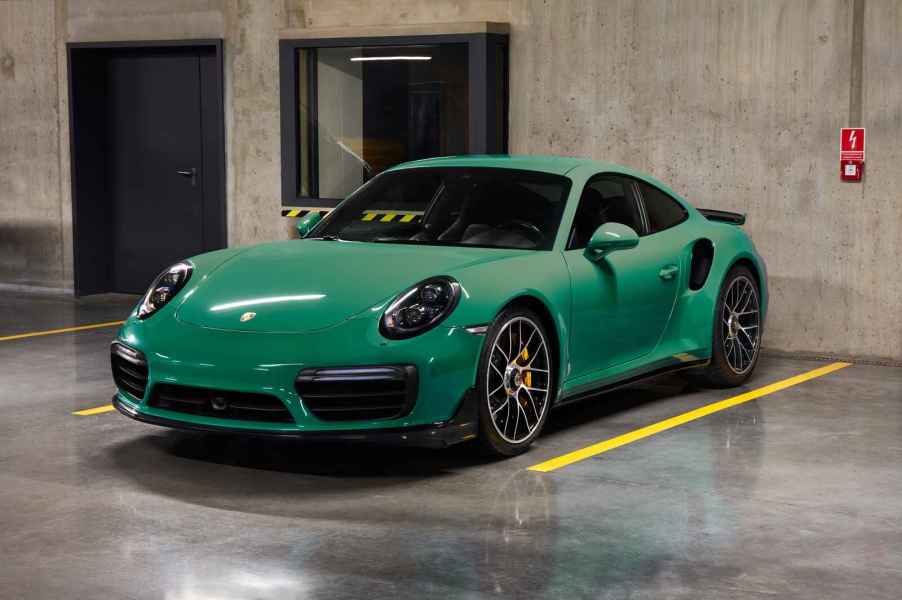 A green Porsche Turbo S parked in a parking garage in left front angle view