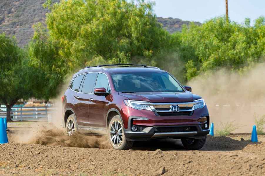 A burgundy 2019 Honda Pilot off-roading in dirt