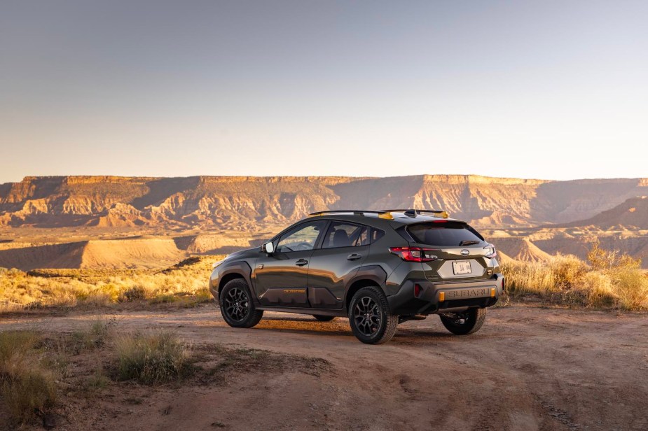 Green Subaru Crosstrek SUV parked off road.