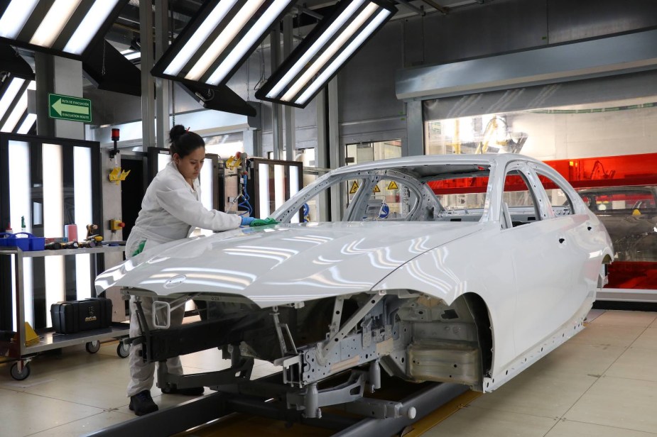 Factory worker preps a 3 Series sedan for paint in a booth at BMW's Mexico plant