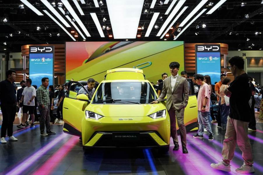 A yellow BYD Seagull, a cheap Chinese electric car grabs a crowd's attention.