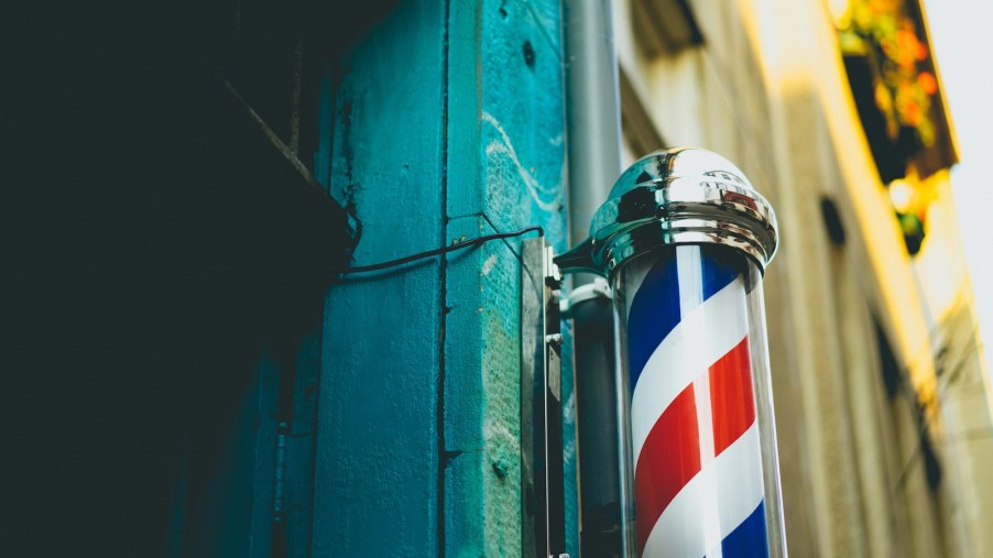 The spinning pole and sign outside a barbershop's door.