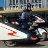 Adam West's Batman on the 1960s Batcycle sidecar motorcycle.