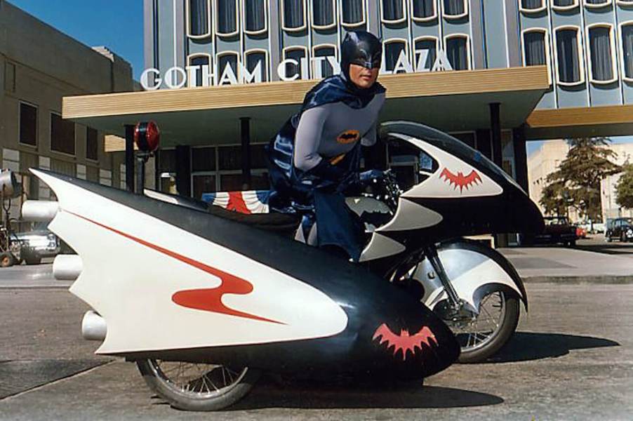 Adam West's Batman on the 1960s Batcycle sidecar motorcycle.