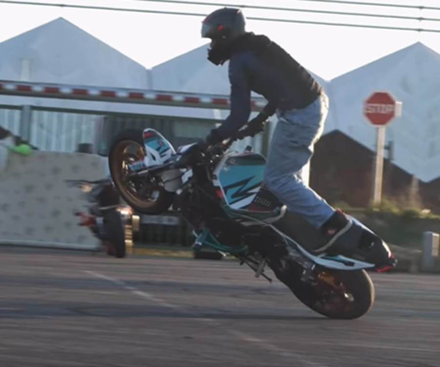 Motorcycle stunt rider Benjamin Baldini leans a bike over in a trick.