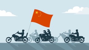 A group of bikers carry a chinese flag.