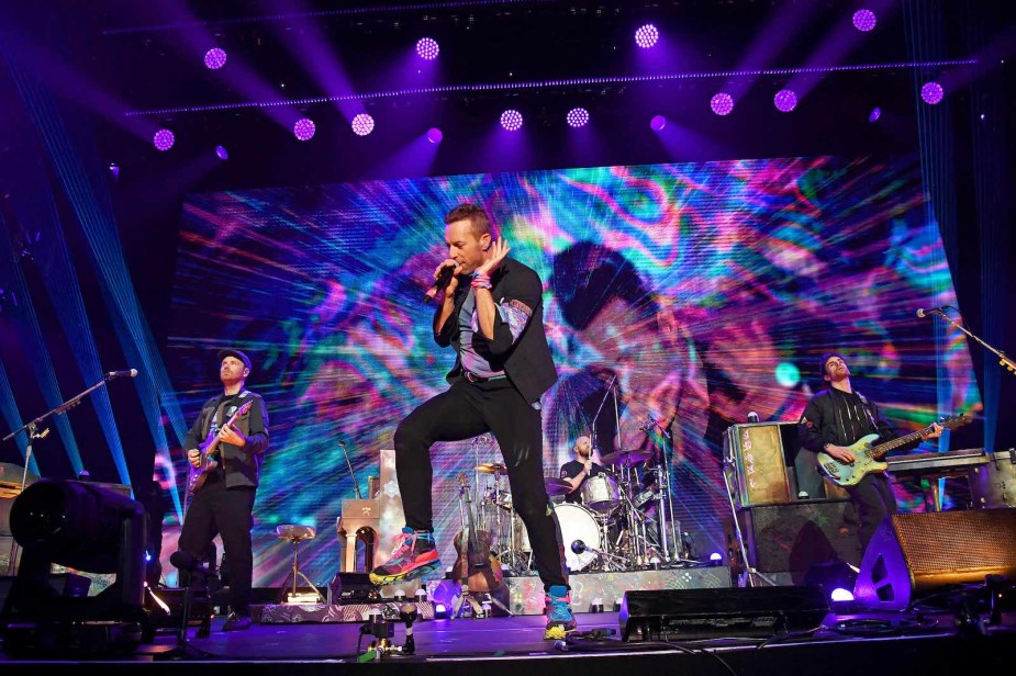 Singer Chris Martin of Coldplay dances on stage.