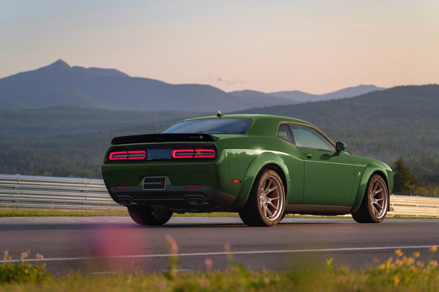 Challenger in F8 Dark green parked in front of a mountain range.