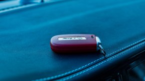 Bright red Dodge SRT Hellcat key fob on a leather seat.