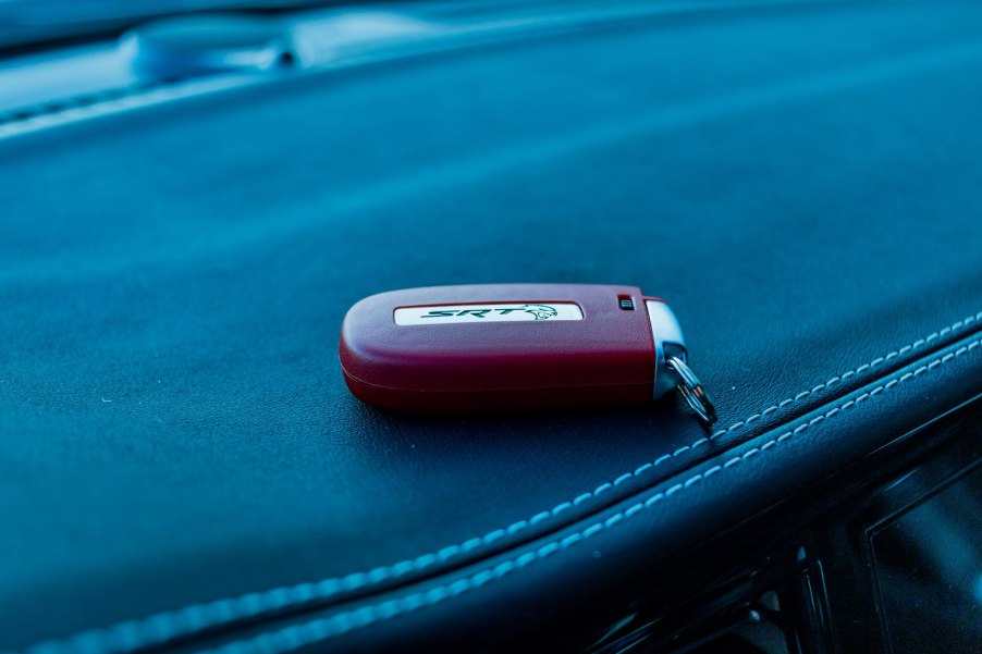 Bright red Dodge SRT Hellcat key fob on a leather seat.