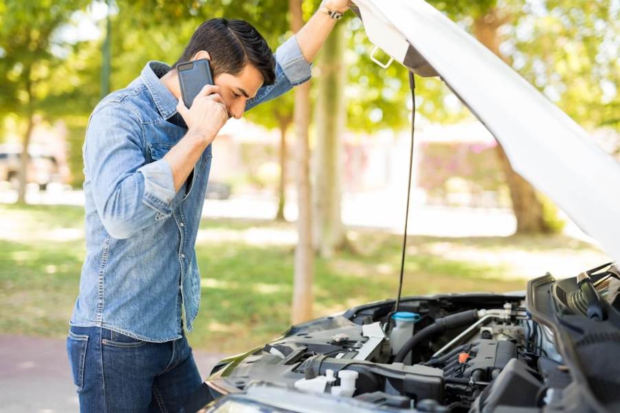 A driver calls for roadside assistance through their insurance provider.