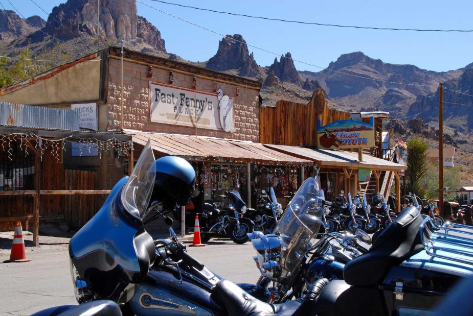 Row of Harleys in front of a biker bar on Route 66 in Arizona, mountains visible in the background.