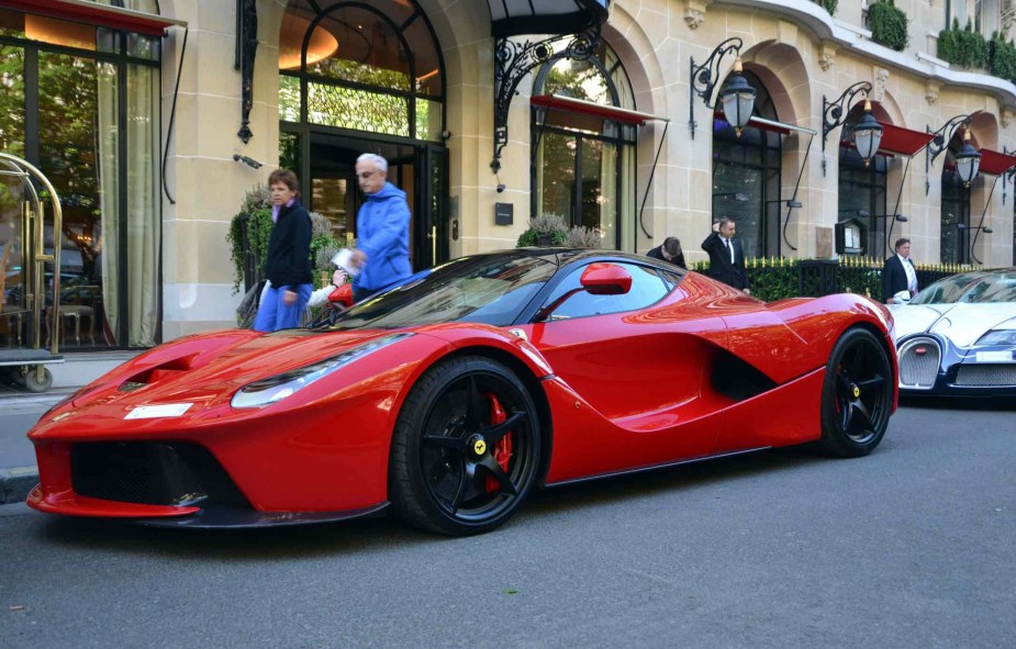 Red Ferrari supercar parked on the street in Paris