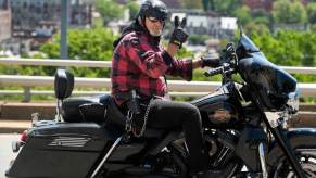 A Harley-Davidson motorcycle rider packs an open-carry handgun in an outer waistband holster.