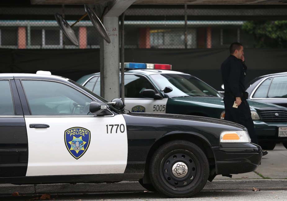 Two Oakland Police Department cruisers parked at an intersection