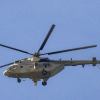 Russian-built Mi-8 helicopter flying in front of a blue sky.