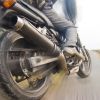 Closeup of a motorcycle riders foot and back tire, the background blurring by