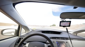 The interior of a Toyota Prius driving down the road.