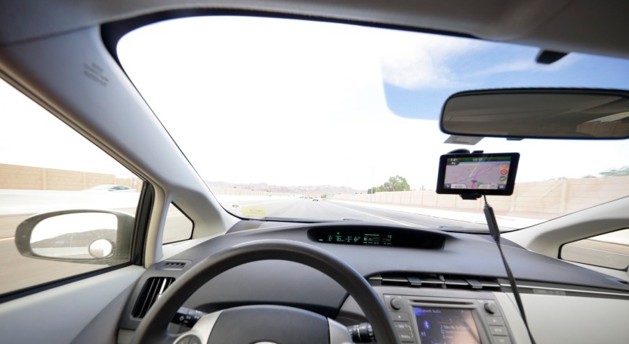 The interior of a Toyota Prius driving down the road.