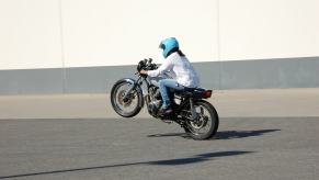 A motorcycle rider performs a wheelie.