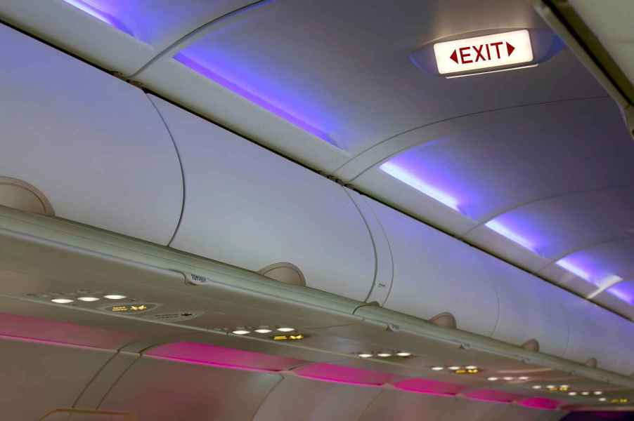 Airplane cabin lights with "exit" sign illuminated