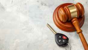 A car key fob placed next to a brown wooden court gavel traffic court