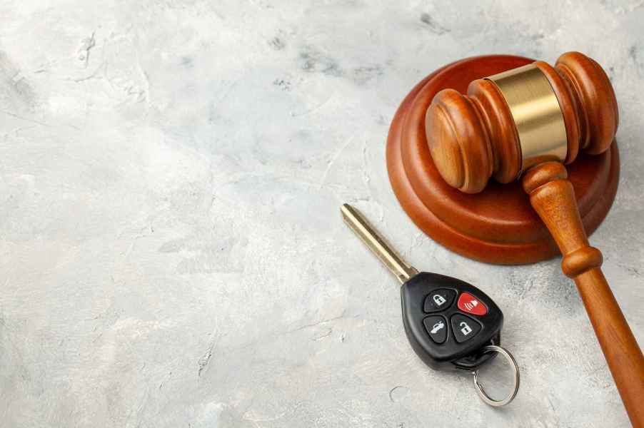 A car key fob placed next to a brown wooden court gavel traffic court