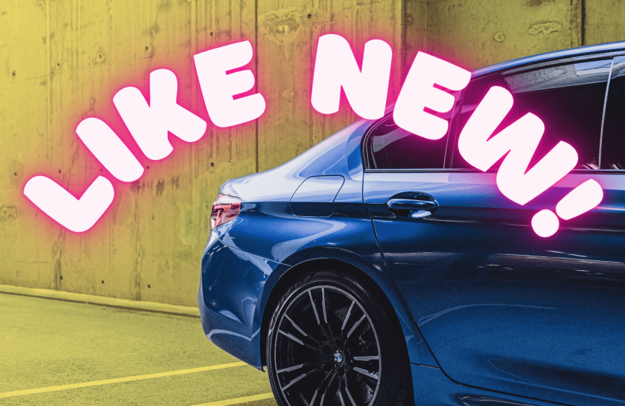 A blue BMW car's right rear quarter with the words "LIKE NEW!" in neon pink