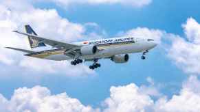 A Singapore Airlines plane flying mid-air with landing gear out