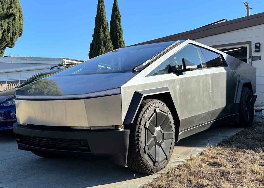 Tesla Cybertruck backed into a home's driveway in left front angle view