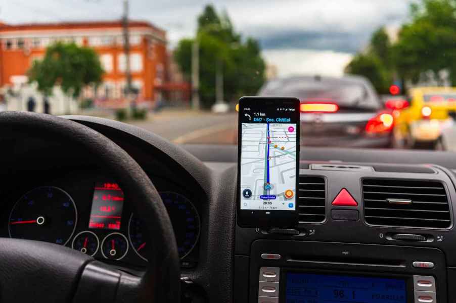 The view from a car with vent-mounted phone displaying Waze map app