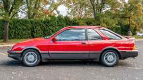 A red 1988 Merkur XR4Ti parked in full left profile view in a parking lot