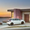 A Nissan LEAF, the cheapest new EV, sits in a driveway.