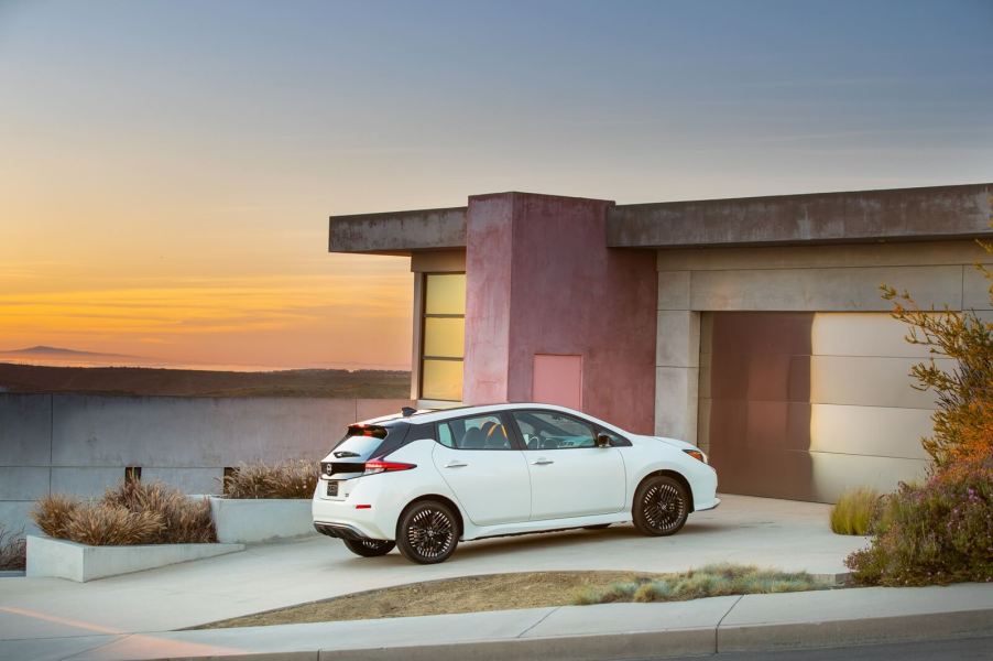 A Nissan LEAF, the cheapest new EV, sits in a driveway.