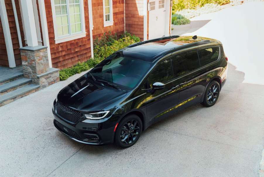 Black Chrysler minivan parked on a sloped driveway.