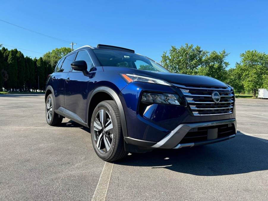 A blue 2024 Nissan Rogue SL AWD shows off its front end styling.