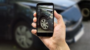 Driver takes photos of car destroyed by accident with their phone.