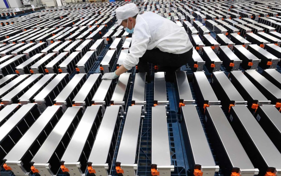 Chinese factory worker building batteries for EVs in a factory.