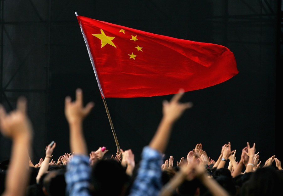 A crowd celebrates Chinese national day by flying a flag