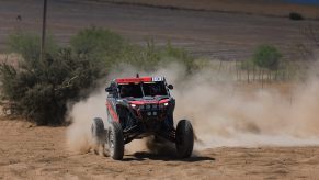 Craig Scanlon kicks up dirt in a red Polaris Factory Racing RZR Pro R Factory model.