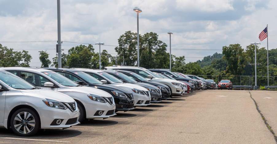 A row of white, black, silver, and gray Nissan cars for sale