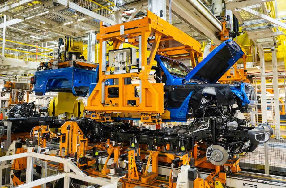 A blue Jeep Gladiator body and bed are lowered on a frame at Stellantis' Toledo assembly plant